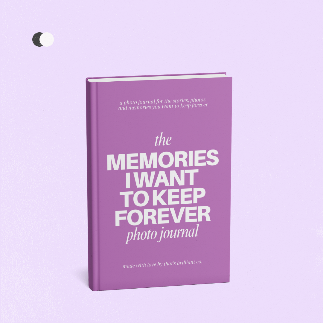 A purple photo journal standing upright on a light lavender background, with white text on the cover reading 'the MEMORIES I WANT TO KEEP FOREVER photo journal'.